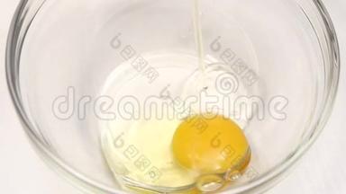 打破鸡蛋在玻璃盘子里烹饪，慢动作。 特写